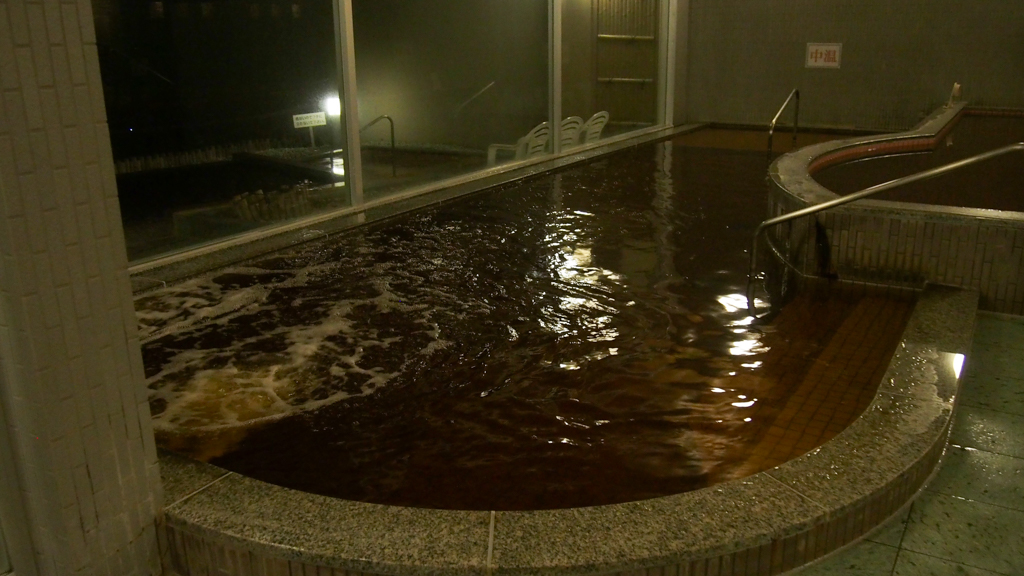 内湯も広め。植物から溶け出した温泉成分で茶褐色の湯
